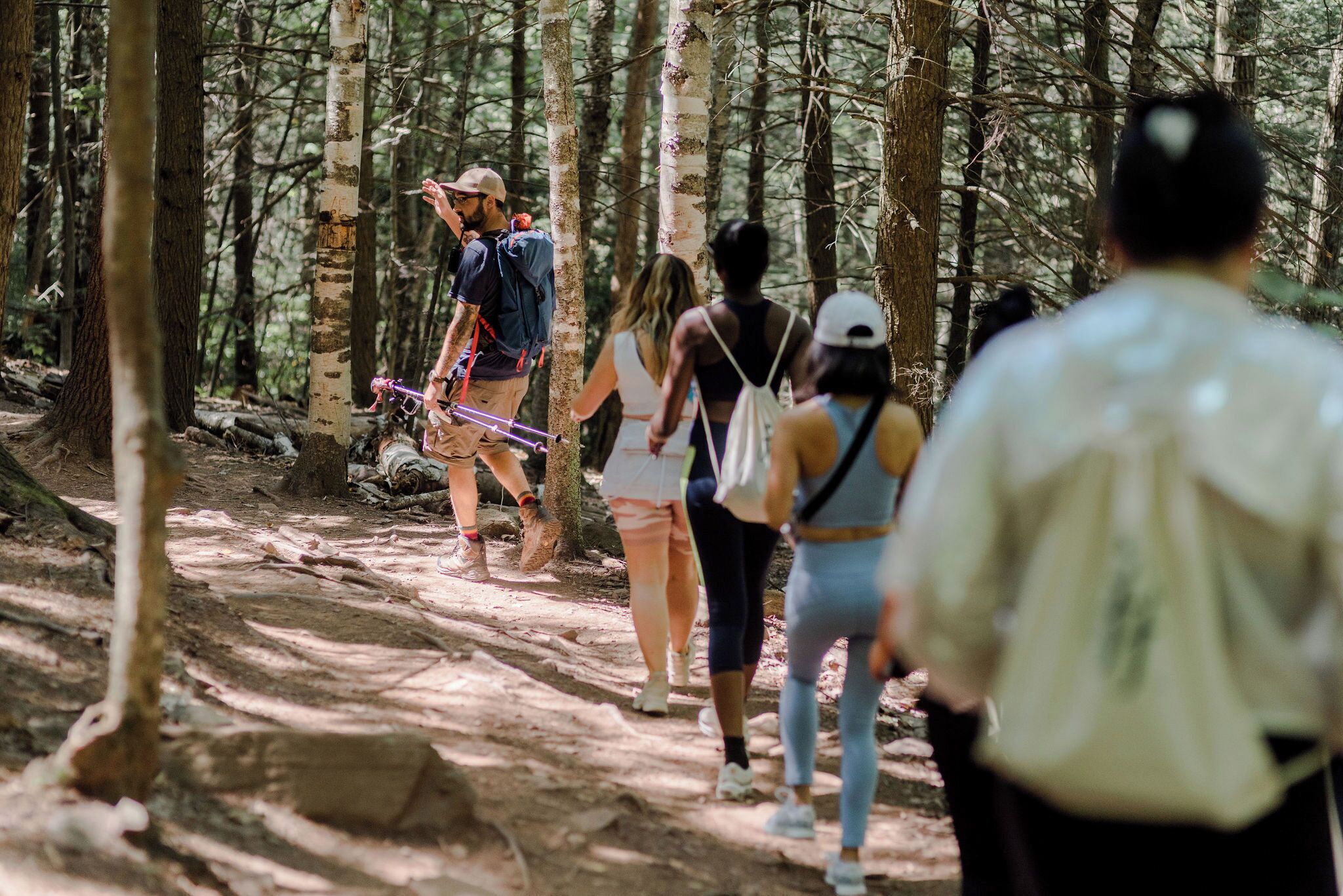 Um grupo de pessoas caminhando por uma trilha na floresta.