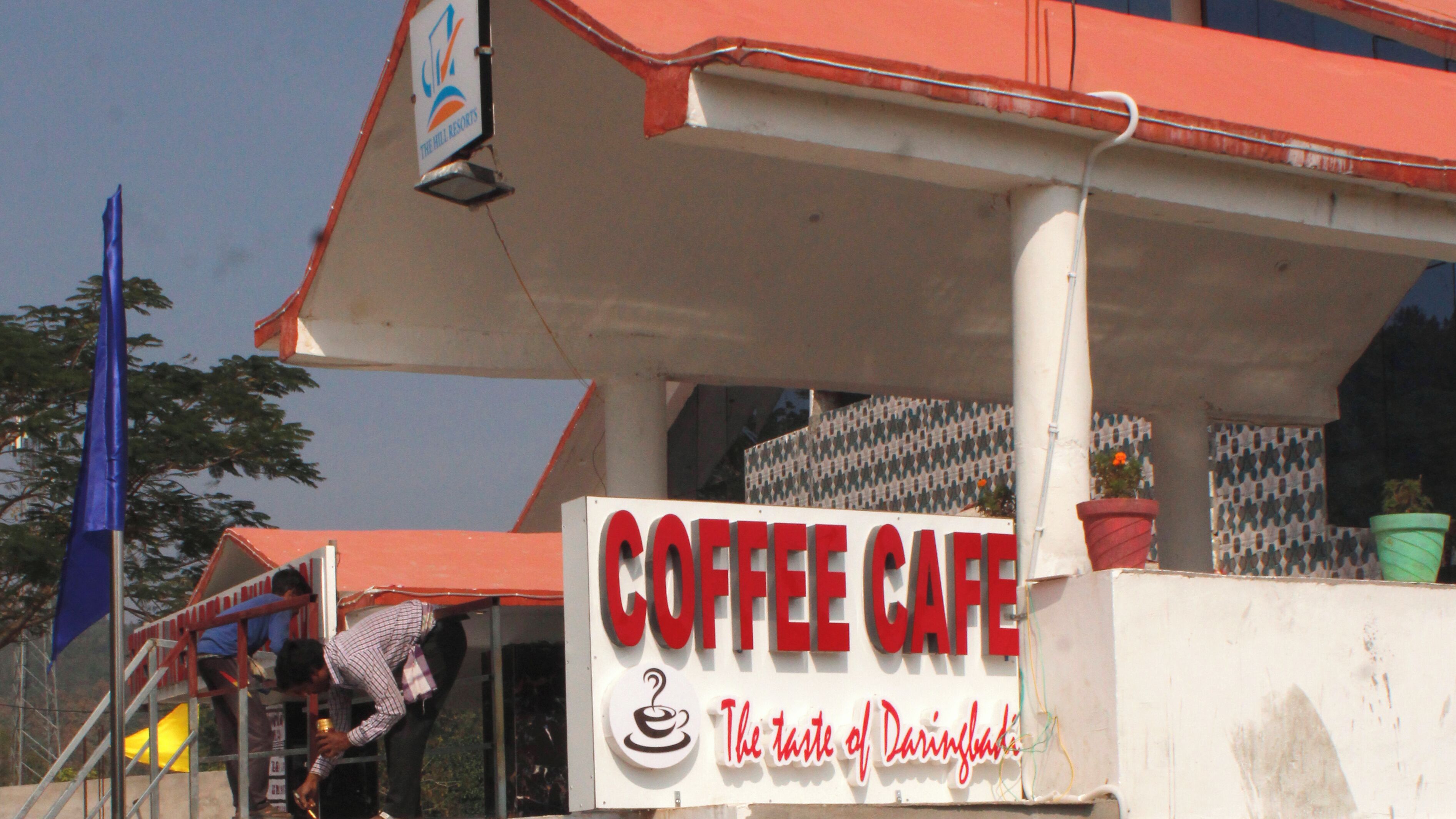 A coffee shop with a sign reading "COFFEE CAFE" and a slogan "The taste of Darinbali".