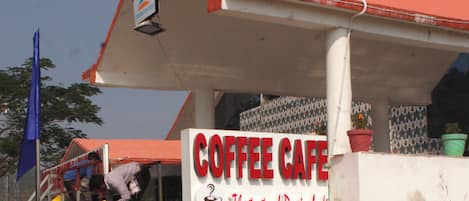 A coffee shop with a sign reading "COFFEE CAFE" and a slogan "The taste of Darinbali".