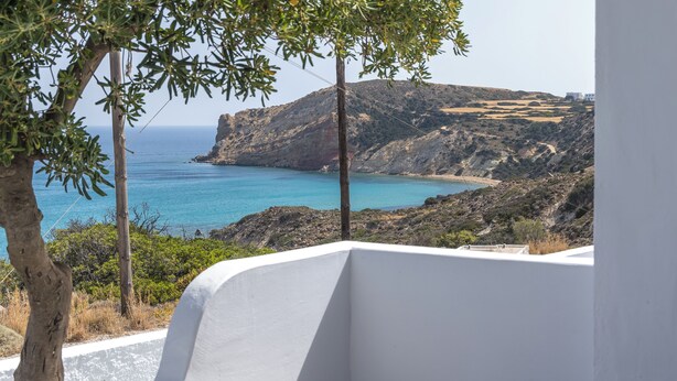 A coastal landscape with a view of the sea and a rocky hillside. - Summer Residence (Milos)