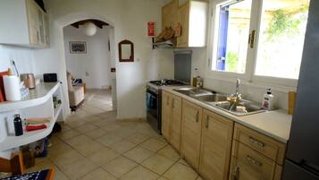 Een oven, een kookplaat, een waterkoker, kookgerei, borden en bestek