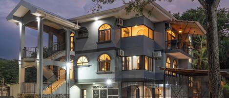 A multi-story building with a stone facade, multiple balconies, and a staircase leading to the upper levels.