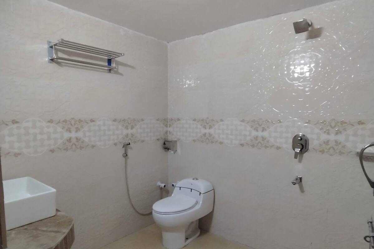 A small bathroom with a toilet, a sink, and a shower.