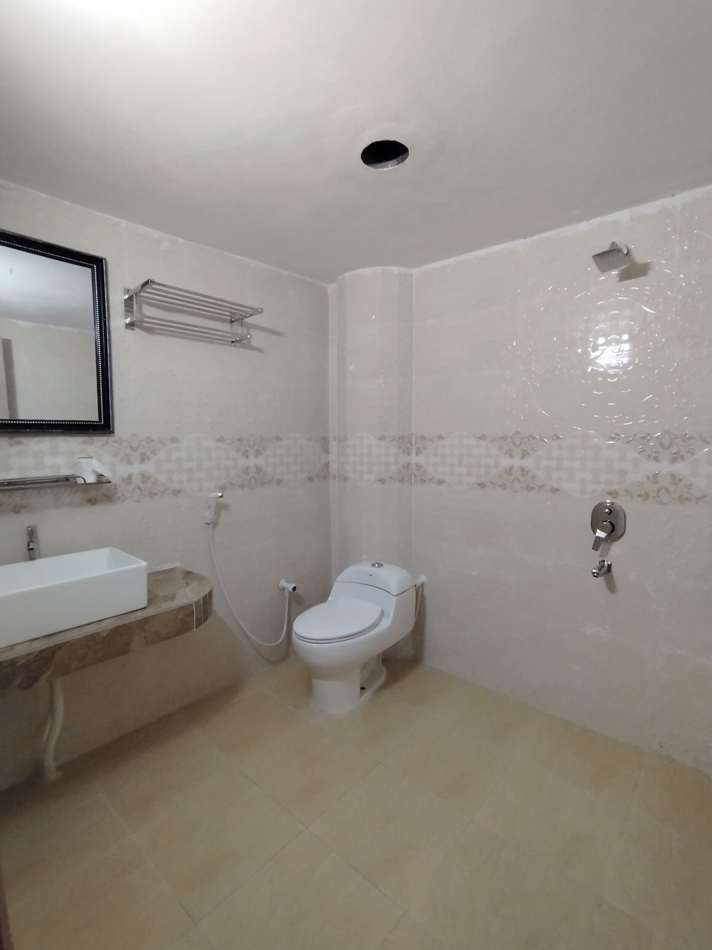 A bathroom with a toilet, sink, and shower.