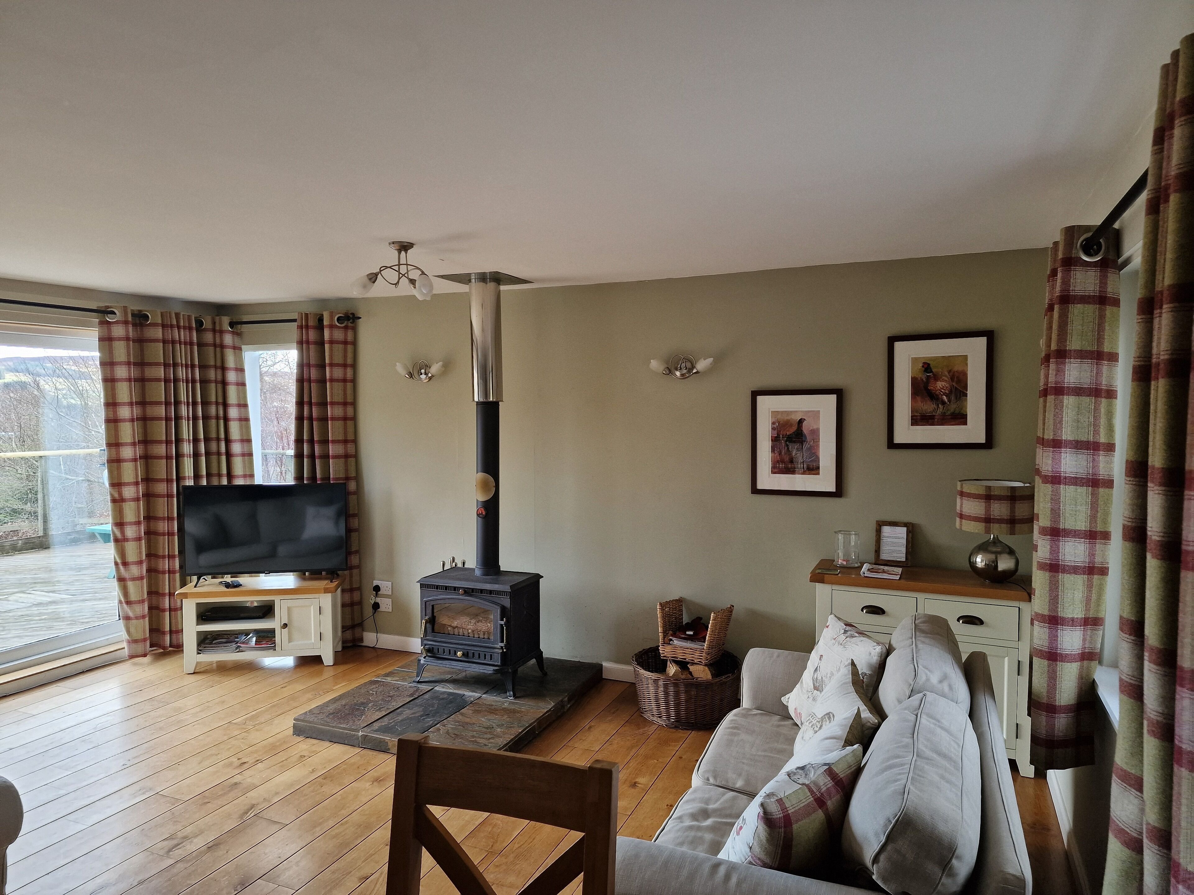 A cozy living room with a fireplace, a television, and a sofa.