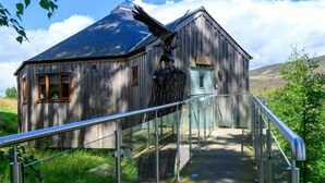 Un bâtiment rustique en bois, doté d’un escalier en métal menant à une porte.