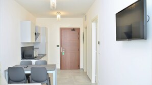 Una cocina moderna con microondas, una mesa de comedor con sillas y una puerta de madera.