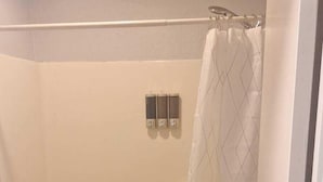 Un baño con bañera, inodoro y cortina de ducha.