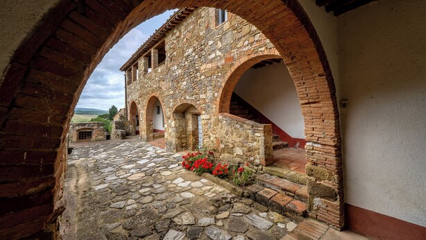 A stone courtyard with arches, a cobblestone floor, and a view of the countryside. - In The Heart Of Chianti Pool Wifi View  (Castellina in Chianti)