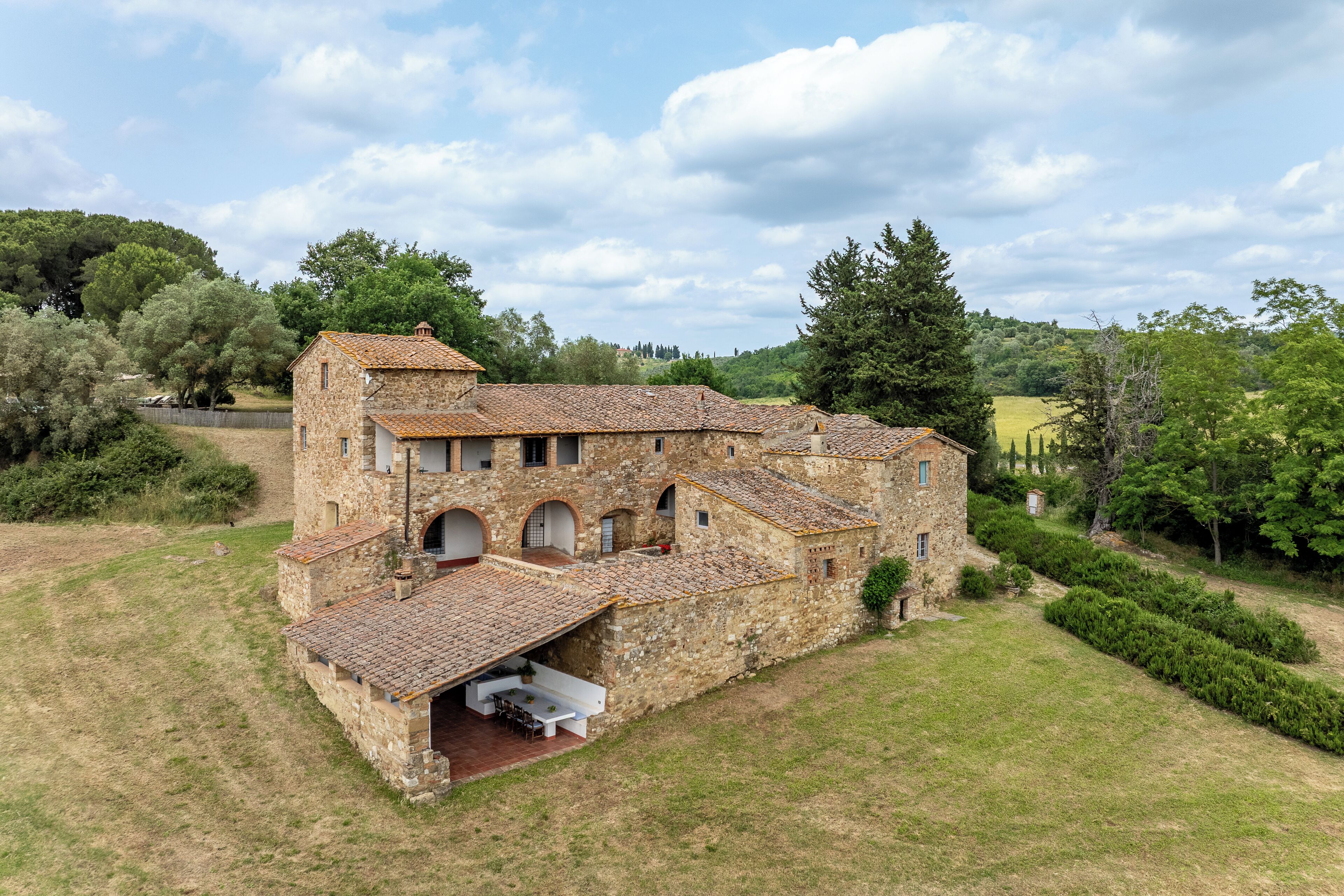 A stone building with multiple arches and a covered patio area.