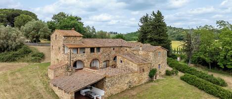 A stone building with multiple arches and a covered patio area.