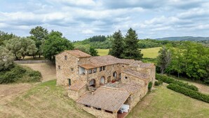 A stone building with multiple rooms and a courtyard, surrounded by greenery and trees. - In The Heart Of Chianti Pool Wifi View  (Castellina in Chianti)