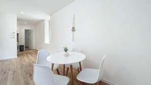 A modern dining area with a round table and four white chairs. - Bright 1-bedroom apartment (Cuxac-d'Aude)