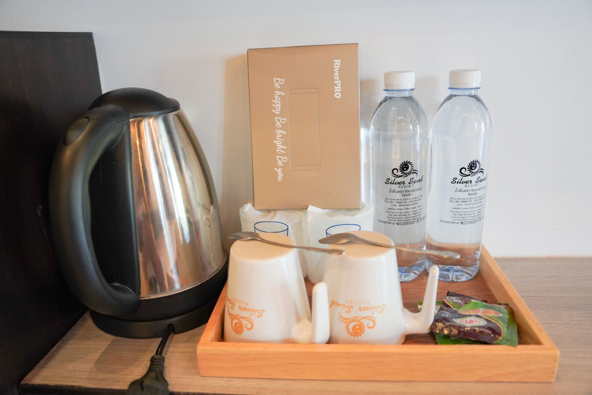 A tray with a kettle, two water bottles, and a box labeled "RiverPro Be happy Be bright."