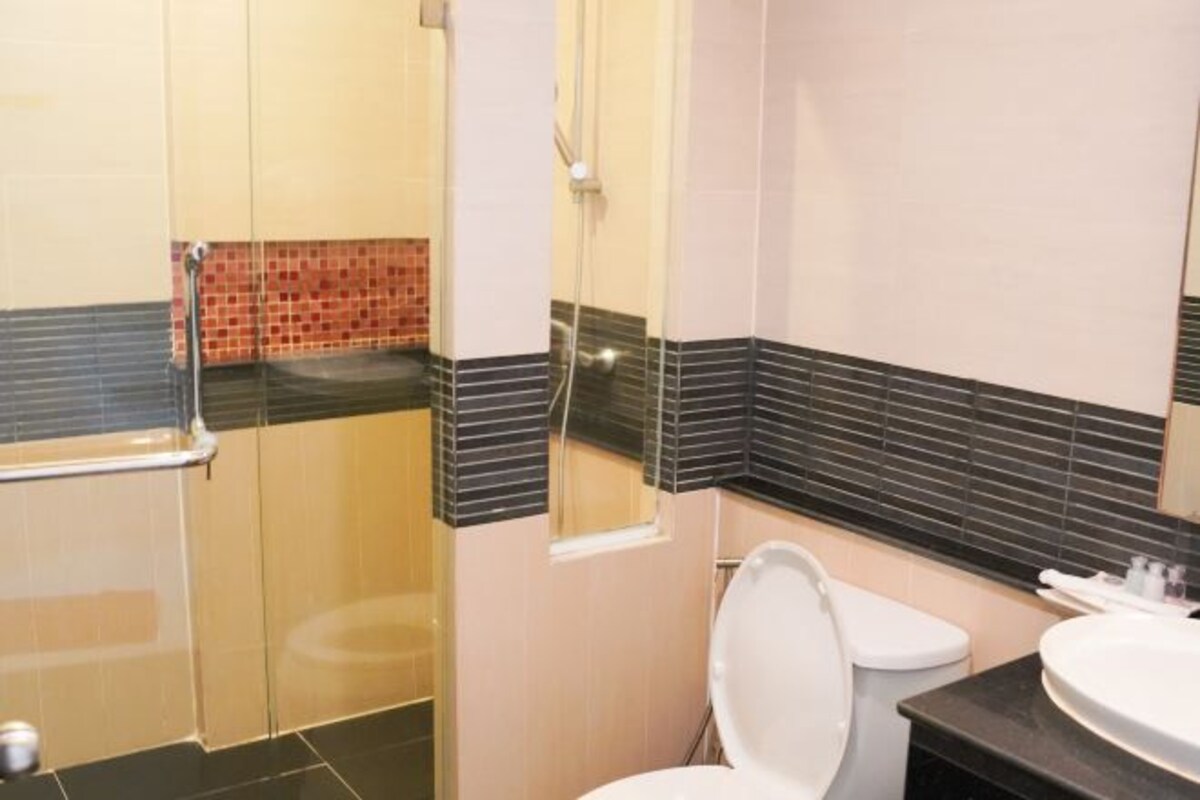 Egy fürdőszoba zuhanyzóval, WC-vel és mosdókagylóval.