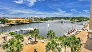 A waterfront promenade with a wooden deck, palm trees, and a view of the water. -  3rd floor 326 Newly Remodeled  Panama City Beach (Panama City Beach)