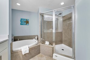 A modern bathroom with a freestanding bathtub, a glass-enclosed shower, and a granite countertop. -  3rd floor 326 Newly Remodeled  Panama City Beach (Panama City Beach)