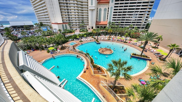A large, multi-level swimming pool complex with multiple pools and sunbathing areas, surrounded by palm trees and high-rise buildings. -  3rd floor 326 Newly Remodeled  Panama City Beach (Panama City Beach)