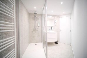Luxe huis | Badkamer | Een douche, een haardroger, handdoeken, zeep