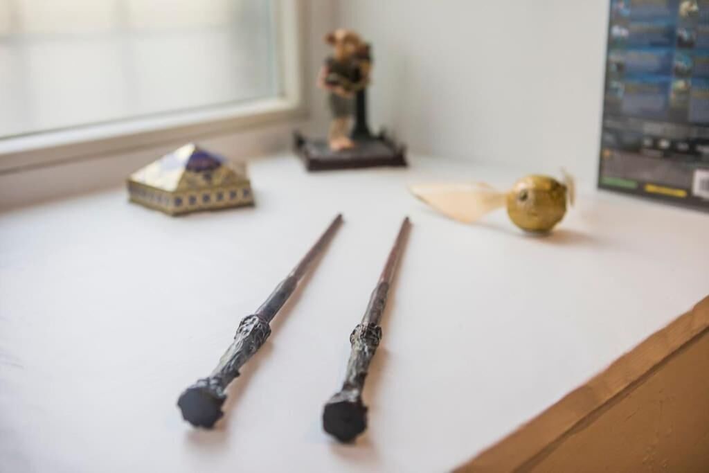Un bureau avec deux baguettes magiques, une petite figurine et un objet en bois.