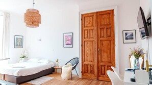 A bedroom with a bed, a chair, a desk, a wardrobe, and a hanging light fixture. - Smart Appart Gare Du Midi (Brussels)