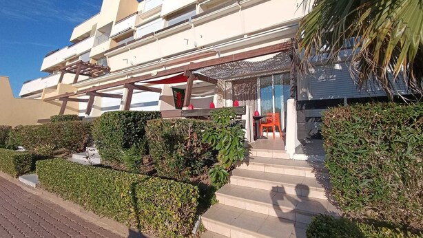 A modern multi-story hotel with a covered outdoor area, steps leading to the entrance, and well-maintained landscaping. - Naturiste Cap d'Agde Port Nature 804 (Agde)