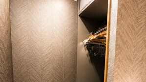 Un vestidor con paredes estampadas, una barra para colgar ropa y estantes empotrados.