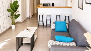 A modern living room with a grey sofa, a coffee table, and a potted plant.