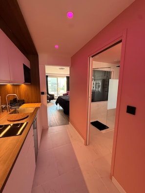 Een moderne keuken met een houten aanrecht en een eethoek met een zwarte tafel.