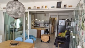 A modern kitchen with white cabinets, a wooden countertop, and pendant lighting.
