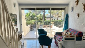 Ein geräumiges Zimmer mit einer Schiebetür zu einem Außenbereich mit Terrasse.