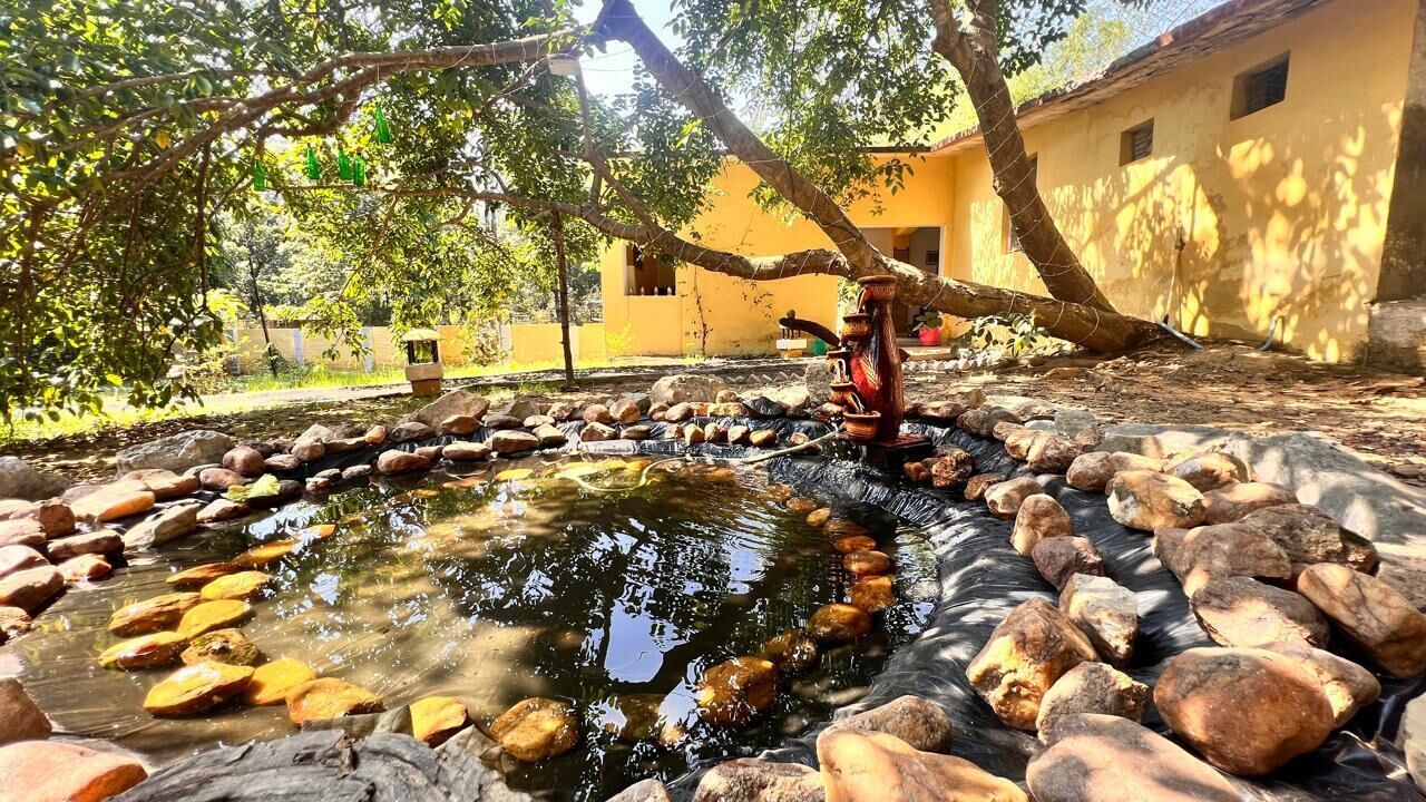 A small pond with rocks and a traditional water pump.