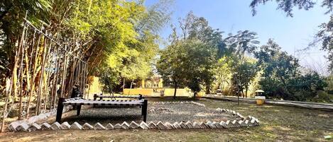 Un parque con un banco, árboles y un sendero.