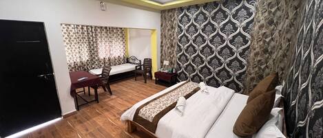 A bedroom with a bed, a desk, and a chair.