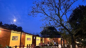 A building with a brick facade, wooden railings, and a courtyard with trees.