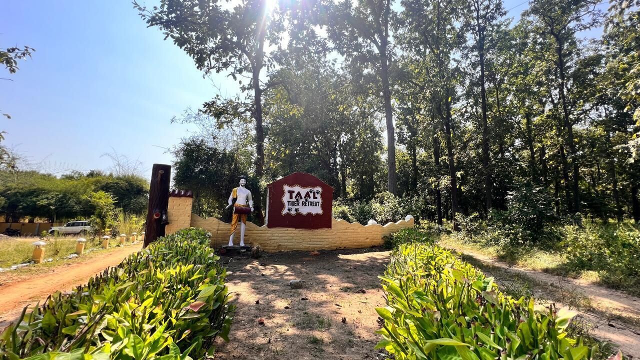 Segnale per un rifugio di tigri con una persona accanto.