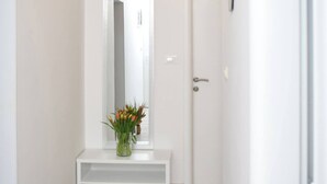 A hallway with a white bench, a door, and a mirror on the wall. - Charming 2-bedroom apartment with WiFi, AC in enchanting Dubrovnik (Dubrovnik)
