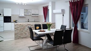 A modern kitchen with white cabinets, a built-in oven, and a stone backsplash. - Charming 2-bedroom apartment with WiFi, AC in enchanting Dubrovnik (Dubrovnik)