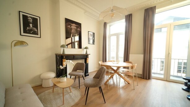 A modern living room with a sofa, chairs, a dining table, and a fireplace. - Smart appart - downtown (Brussels)