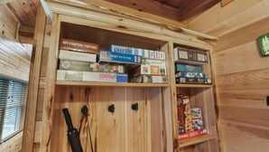 A wooden shelf with various board games and puzzles. - Falling Leaves | Hocking Hills, Accessible, Pets (South Bloomingville)