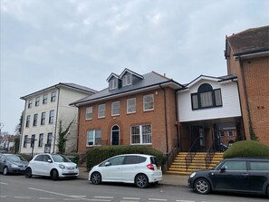 A row of residential buildings with a white car parked in front. - Roomspace Apartments - Harvest Lane (Thames Ditton)