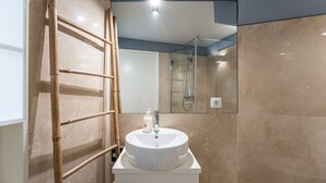 A bathroom with a white sink, a mirror, and a shower. - GuestReady - Souto Studio 4|4th floor|No elevator (Porto)