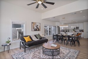 A spacious living room with a black sofa, a round coffee table, and a patterned rug. - Create Memories 4BR 3BA Near Riverwalk Downtown (San Antonio)
