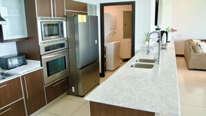 A modern kitchen with stainless steel appliances, a marble countertop, and a built-in oven. - Duplex Penthouse with Ocean View in Tamarindo, 5 min walk to the beach (Tamarindo)