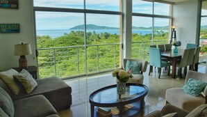 A spacious living area with a large balcony overlooking a scenic view of the sea and greenery. - Duplex Penthouse with Ocean View in Tamarindo, 5 min walk to the beach (Tamarindo)