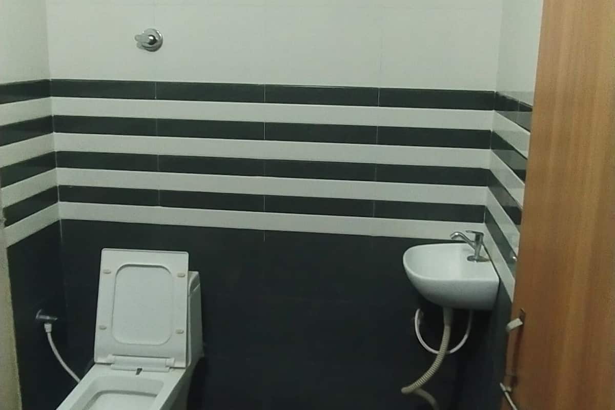 Un baño pequeño con inodoro, lavamanos y piso estampado.