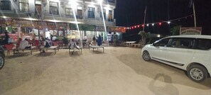 A hotel with outdoor seating and a white car parked in front. - Baba Ramdev Hotel And Restaurant  (Degana)