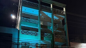 Um edifício de vários andares com fachada de vidro e uma placa com a inscrição 'ALUGA-SE'.