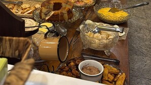 Um buffet com diversos alimentos e utensílios.