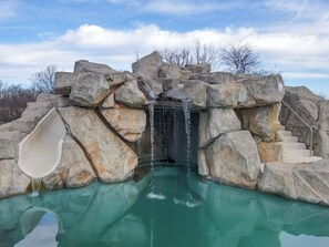 A rock formation with a water slide and a pool. - The Bluegrass Grand Estate: Bourbon Trail Luxury (Bardstown)